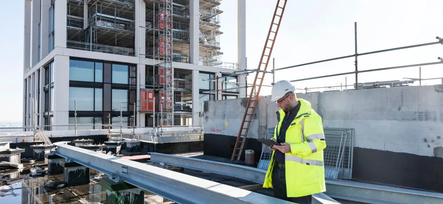 Site engineer checking construction document control records on a tablet
